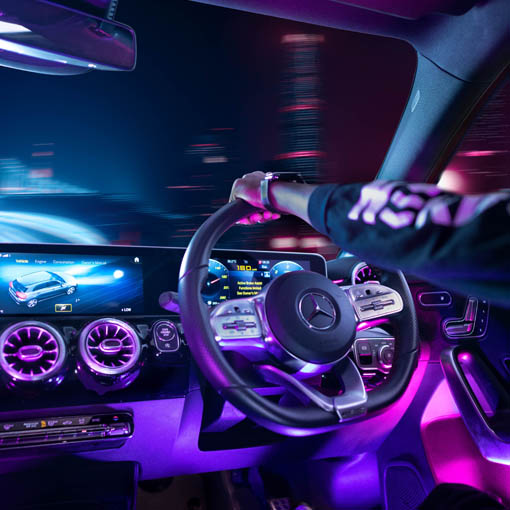 Interior view of car, night-time, with neon streets outside