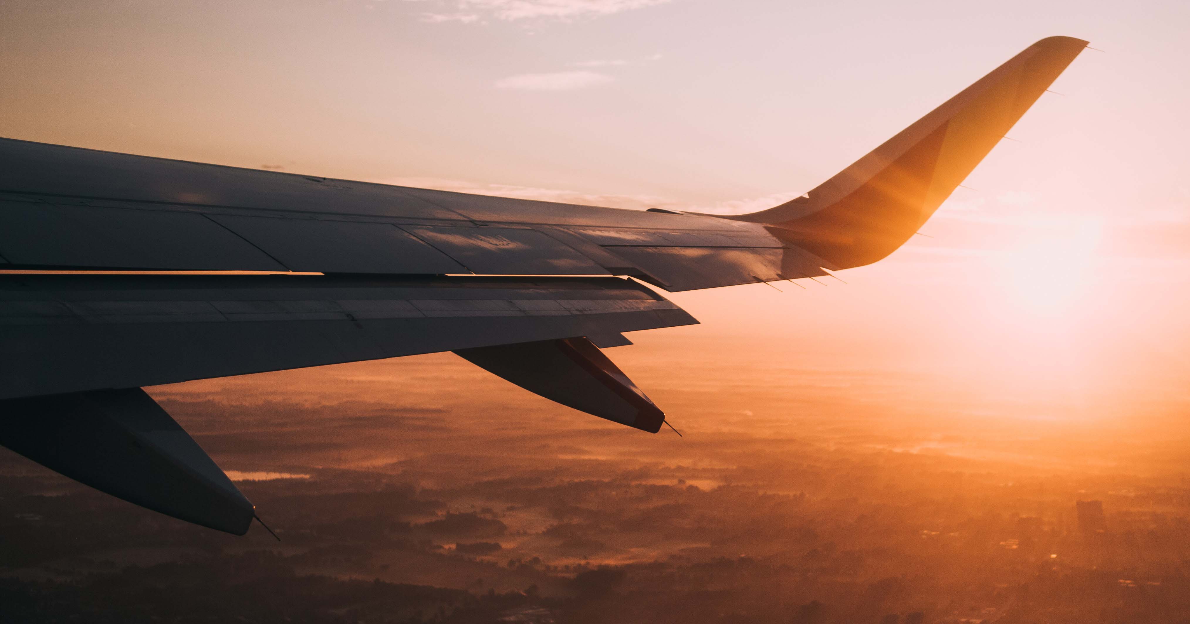 Image of an aeroplane wing agaist a dawn sky.