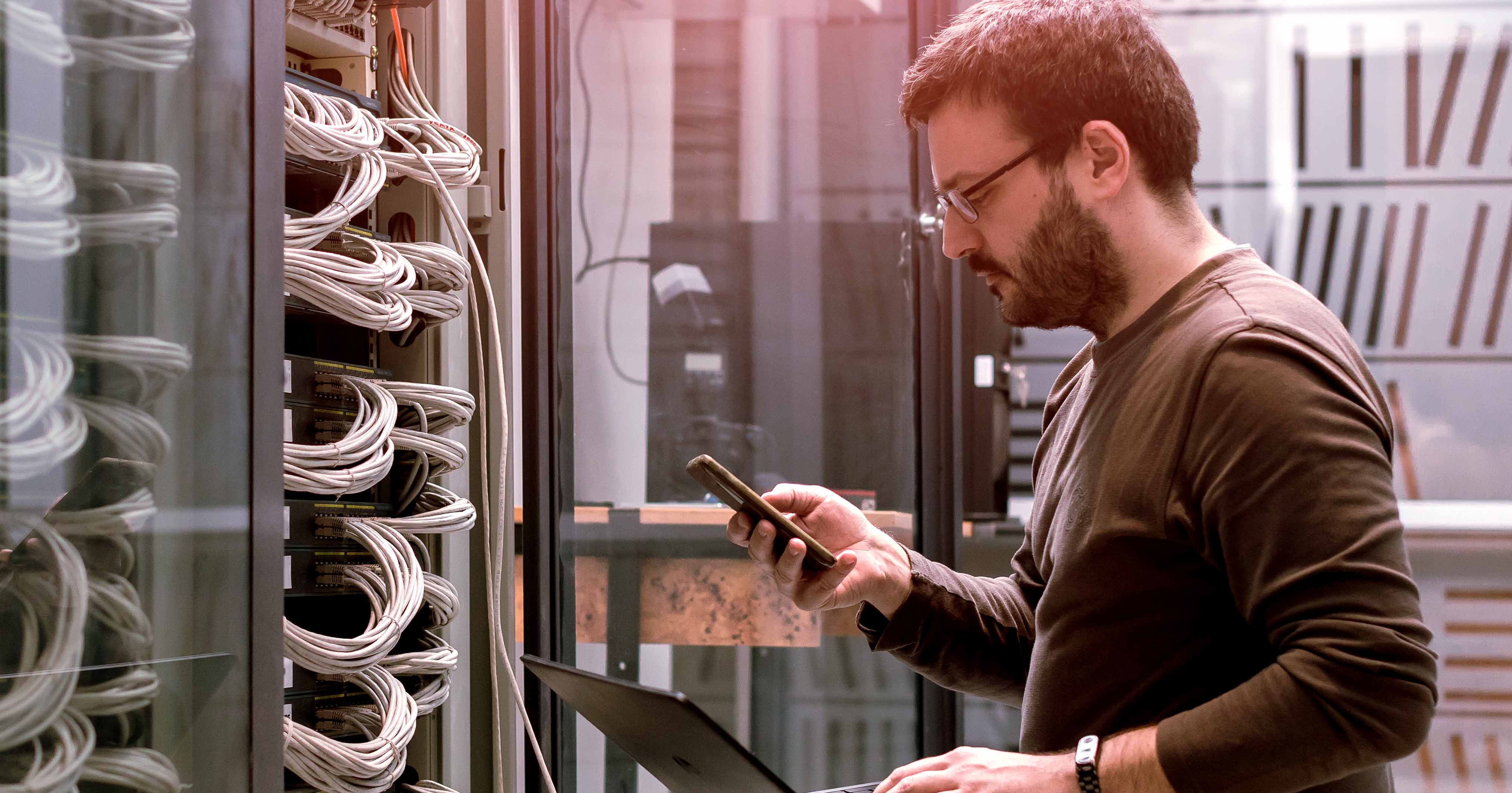 Iamge of a network engineer working in a server room.