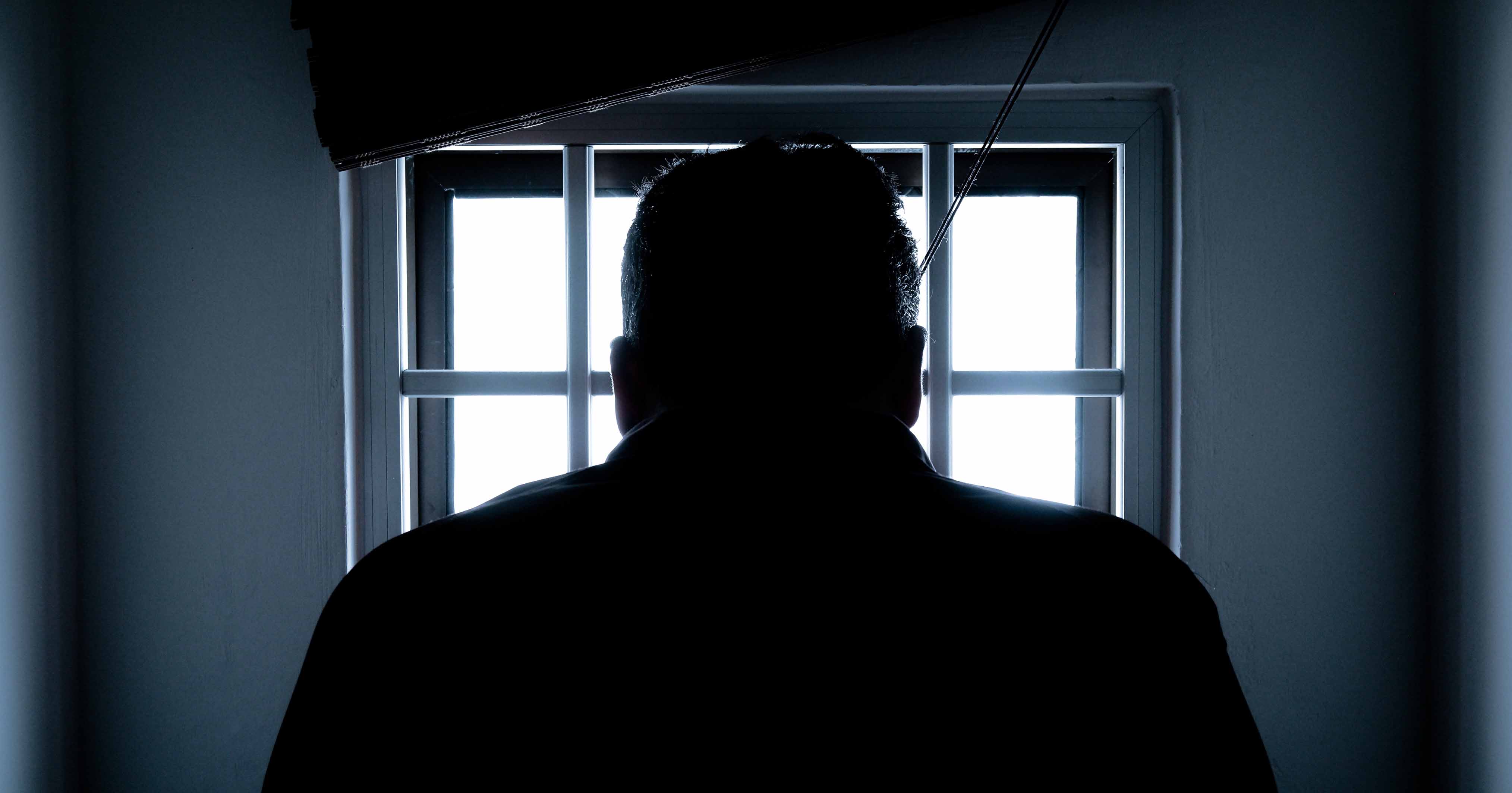 Man silhouetted against a window.